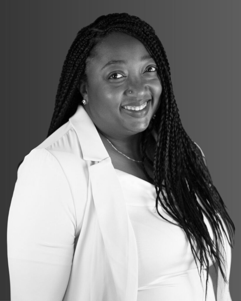 Professional headshot of Rachel Melville, smiling, wearing business attire, against a neutral background.